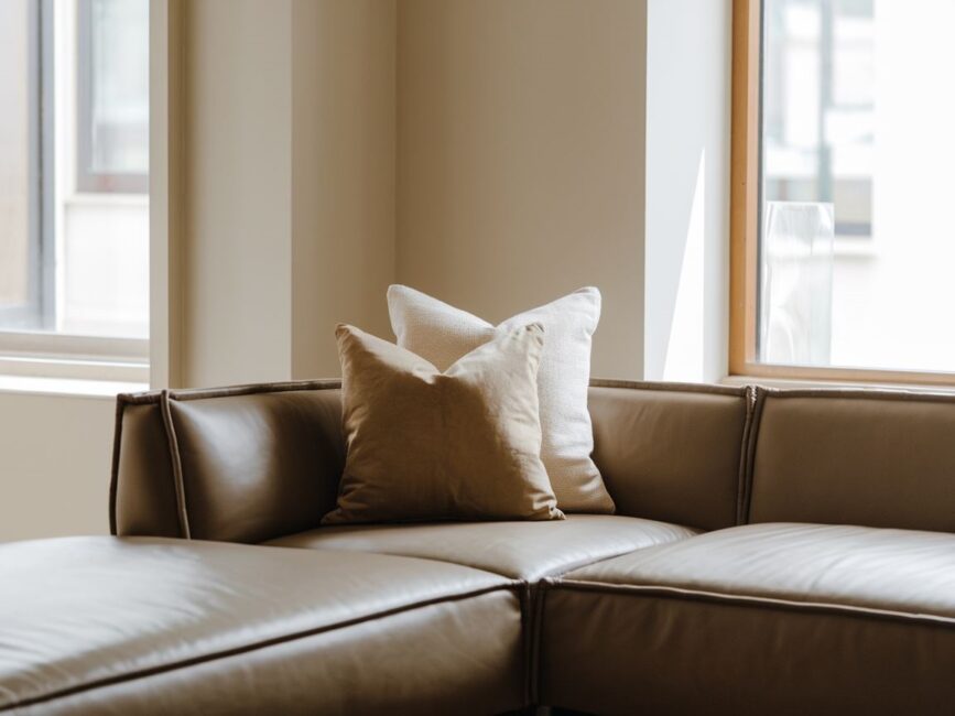 Kolorowe poduszki na narożniku w stylowym salonie